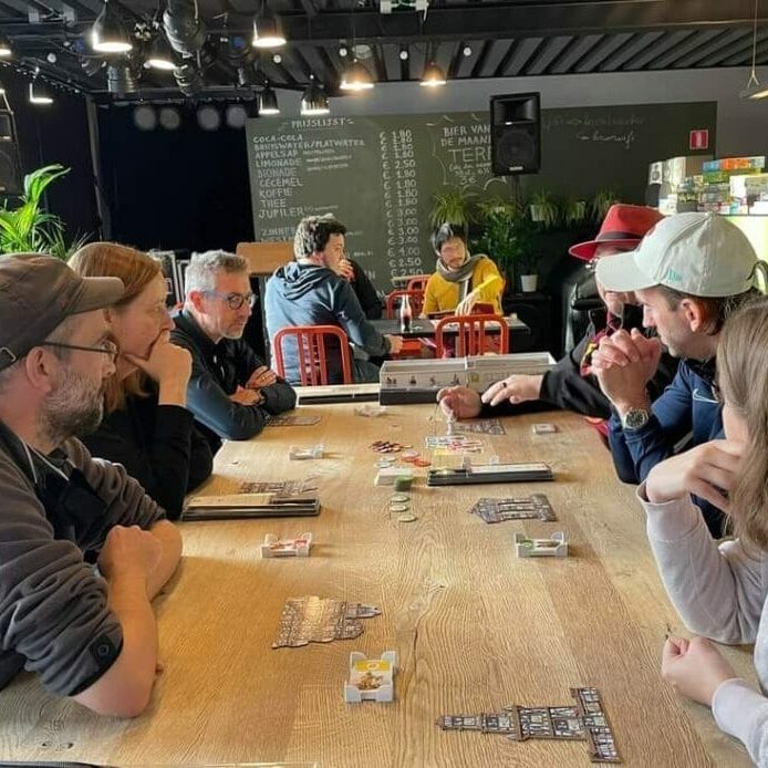jeux-dis-jeux hommes et femmes autour d'une table en train de jouer à un jeu de société
